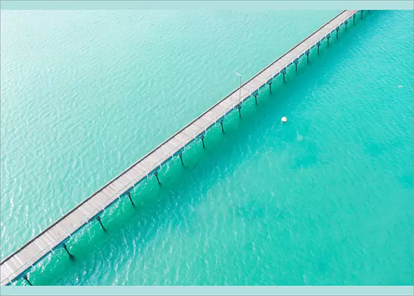 Long jetty out into the clear aqua ocean water