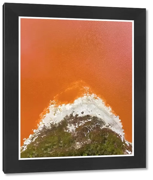 Composed drone shot at the edge of an orange coloured salt lake, South Australia, Australia
