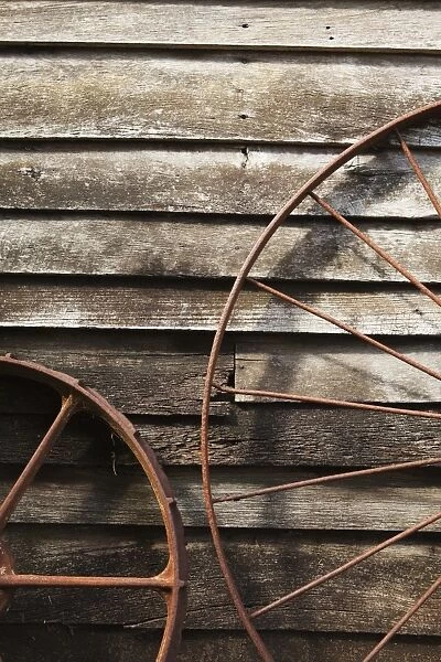 Old Wagon Wheels Against A Wooden Wall
