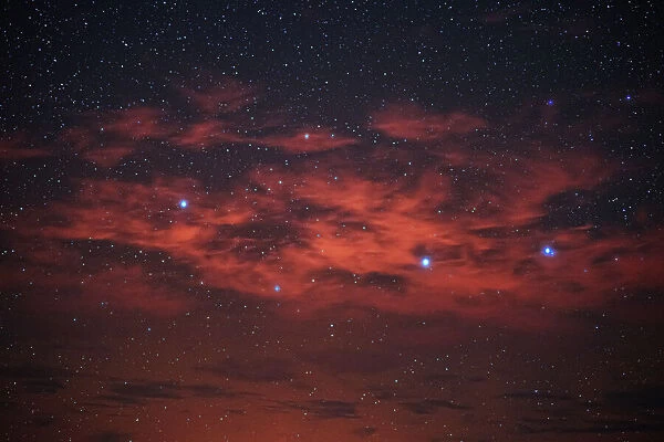 Starry night sky with red clouds