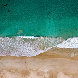 Aerial shot above turquoise ocean and beautiful sandy beach