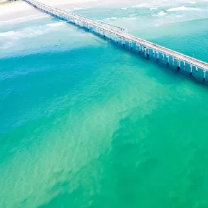 Drone view of a Long sand pumping jetty out into the clear ocean water