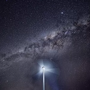 Wind turbine spinning at night with the Milky Way in the sky