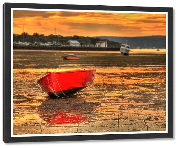 Red boat. Bright red boat in foreground on muddy shore at low tide
