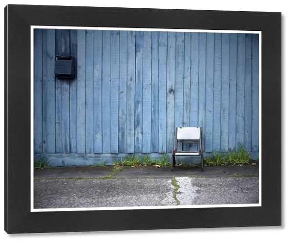 Chair in front of blue fence
