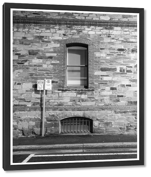 Side wall of building with air vent, window & sign