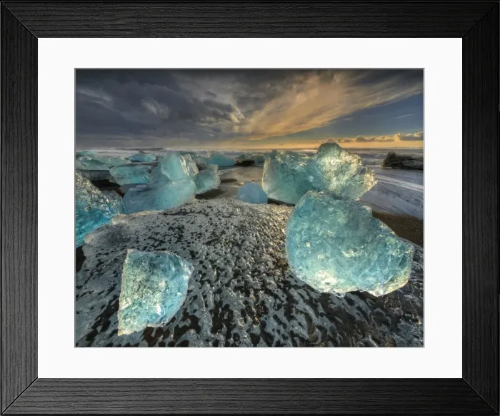 Framed Print : Jokulsarlon Beach in winter, just after a huge storm hit the coastline. Ice bergs from the nearby lagoon have been swept up onto the coastline and surge in and out with the tide