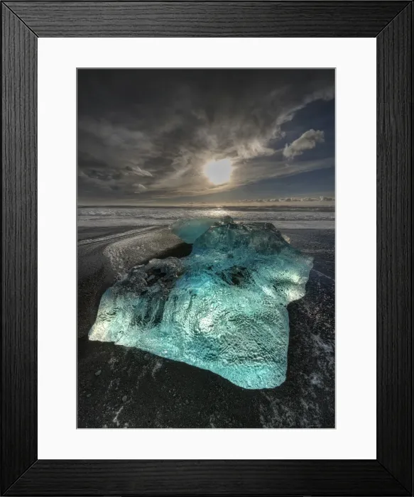 Framed Print : Jokulsarlon Beach in winter, just after a huge storm hit the coastline. Ice bergs from the nearby lagoon have been swept up onto the coastline and surge in and out with the tide