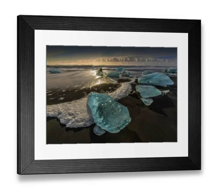 Framed Print : Jokulsarlon Beach in winter, just after a huge storm hit the coastline. Ice bergs from the nearby lagoon have been swept up onto the coastline and surge in and out with the tide
