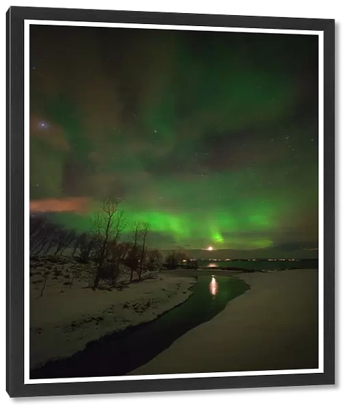 Aurora Borealis lights up the sky behind the city of Akureyri, Iceland