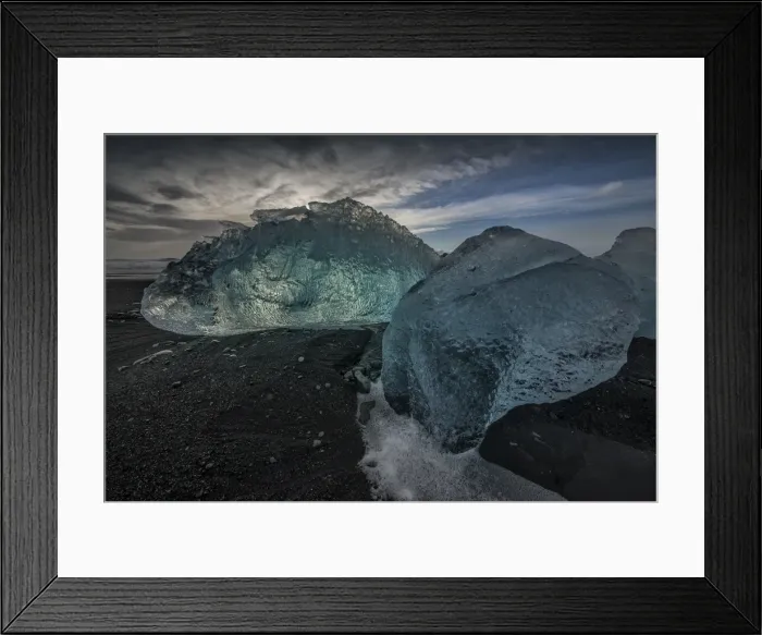 Framed Print : Jokulsarlon Beach in winter, just after a huge storm hit the coastline. Ice bergs from the nearby lagoon have been swept up onto the coastline and surge in and out with the tide