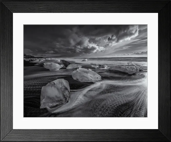 Framed Print : Jokulsarlon Beach in winter, just after a huge storm hit the coastline. Ice bergs from the nearby lagoon have been swept up onto the coastline and surge in and out with the tide