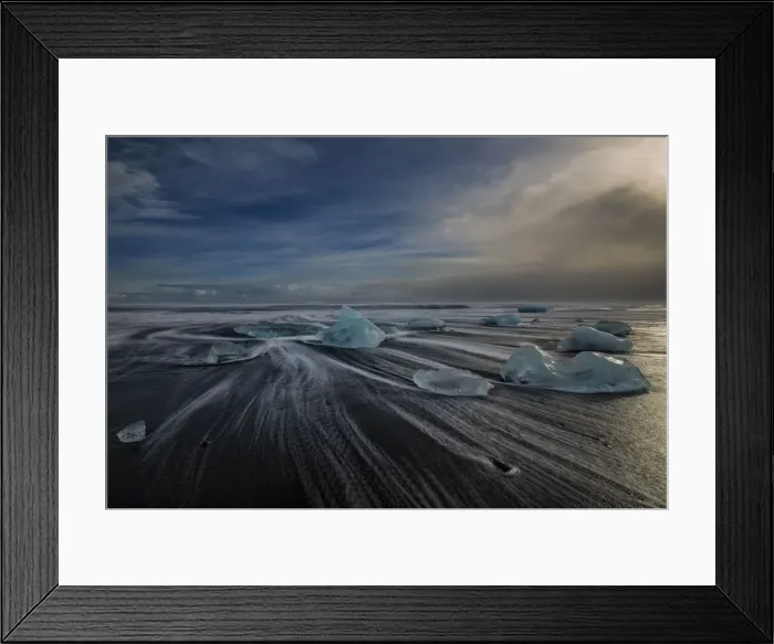 Framed Print : Jokulsarlon Beach in winter, just after a huge storm hit the coastline. Ice bergs from the nearby lagoon have been swept up onto the coastline and surge in and out with the tide