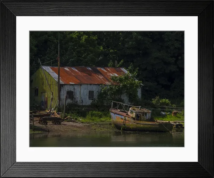 Framed Print : Old boatshed and derelict fishing boat moored on the river at Caernarfon, Northern Wales, United kingdom