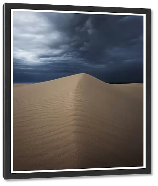 Sand dunes with storm clouds