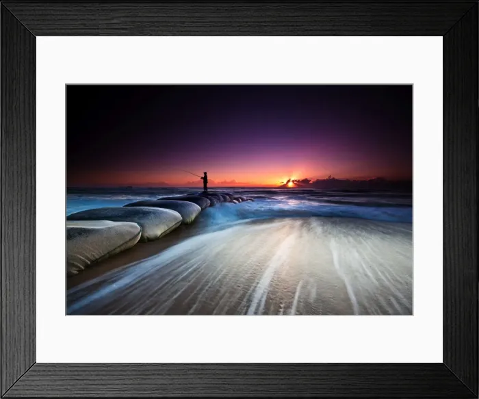 Framed Print : Fisherman standing on huge sandbags