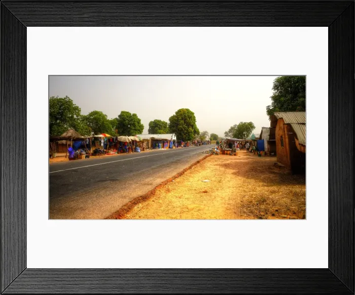 Framed Print : Road market in rural Gambia with colourful stalls, clear sky and no cars Framed Print : Road market in rural Gambia with colourful stalls, clear sky and no cars