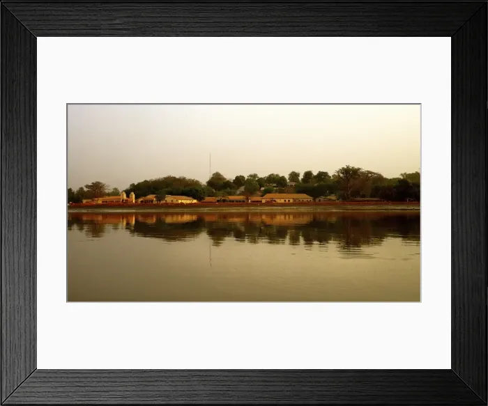 Framed Print : River Gambia at sunset with Tendaba settlement reflections on calm water during sunset