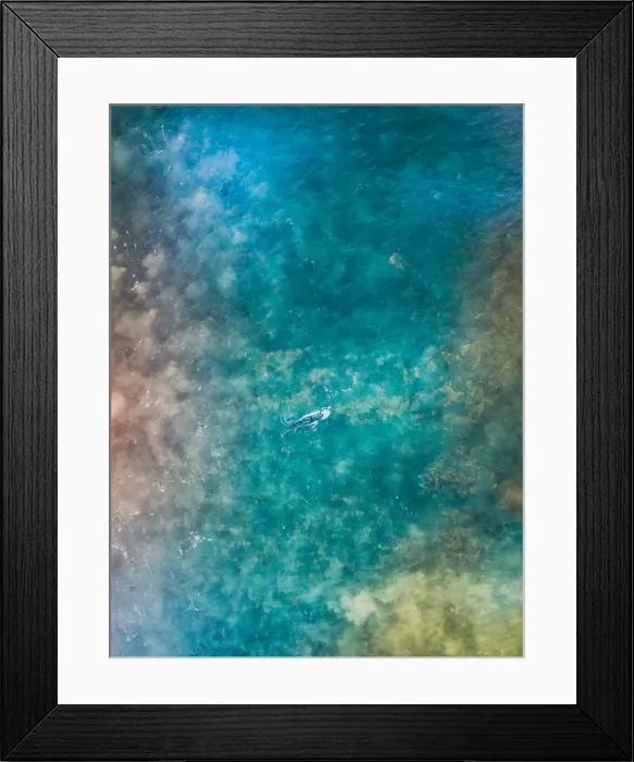 Framed Print : Aerial view of a female surfer on the ocean