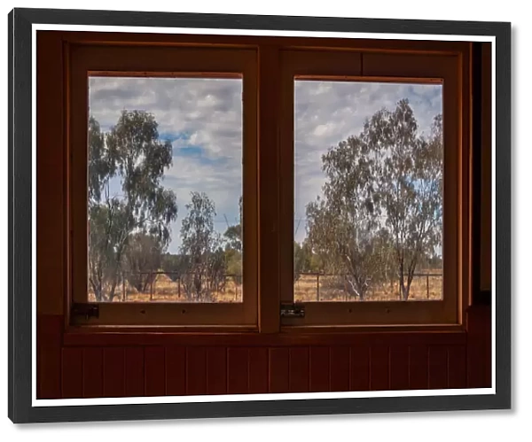 An arid landscape framed by train windows