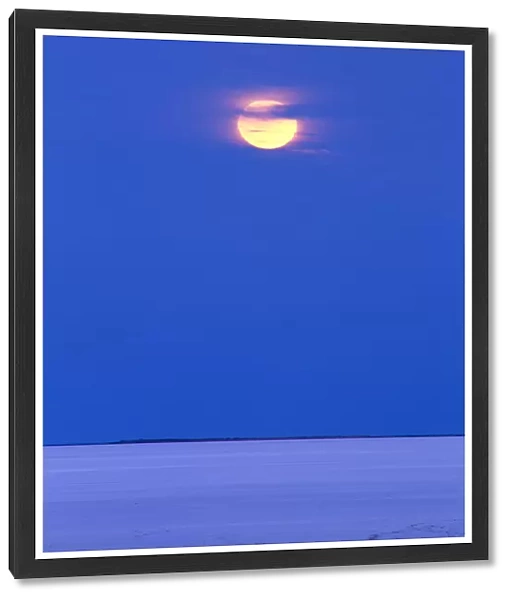 Moon rising over dry salt lake in desert