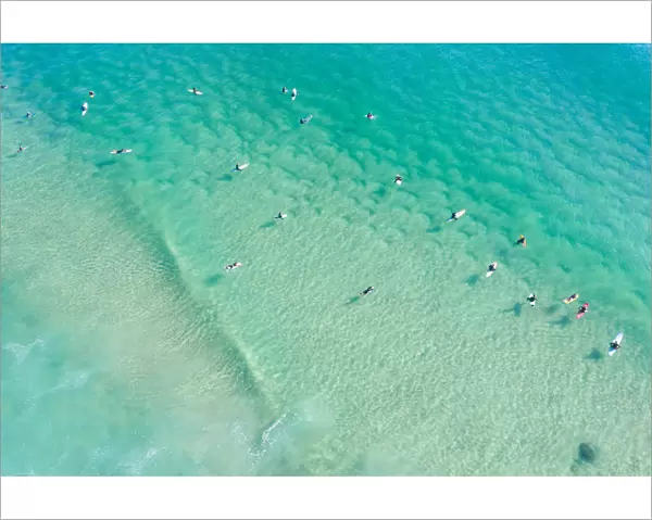 Aerial point of View crystal clear ocean waters with people surfing