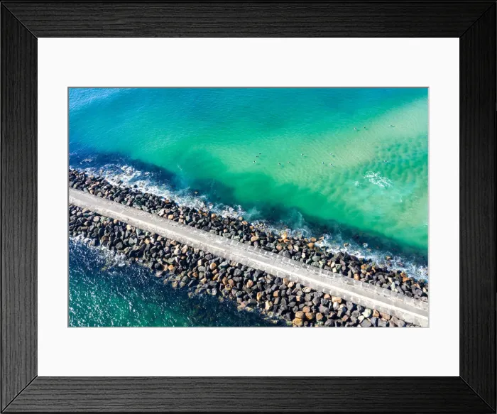 Framed Print : Aerial View of rock walkway out into the ocean with surfers Framed Print : Aerial View of rock walkway out into the ocean with surfers