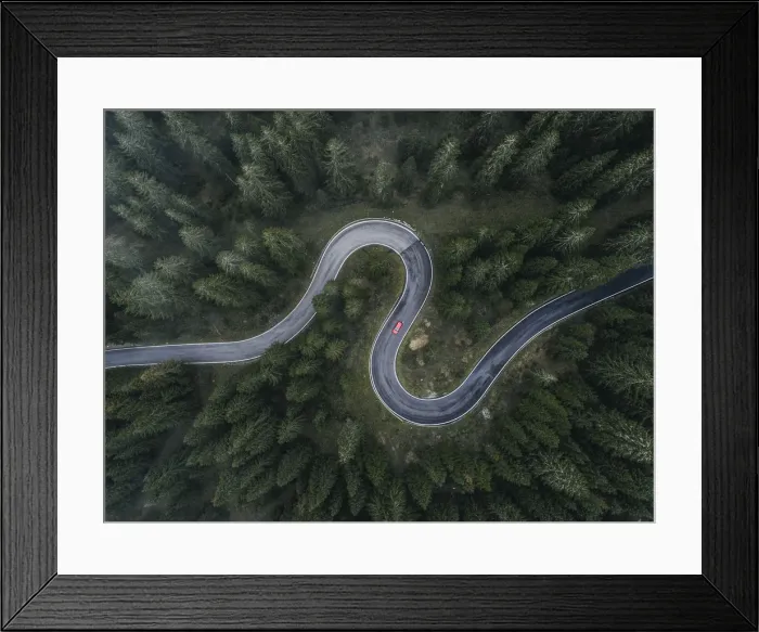 Framed Print : Winding forest road seen and a car shot by drone, Dolomites, Italy Framed Print : Winding forest road seen and a car shot by drone, Dolomites, Italy