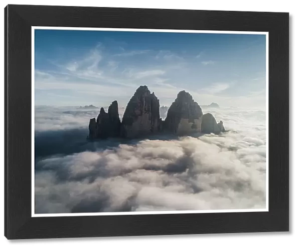 Majestic aerial shot above the clouds looking towards Tre Cime Di Lavaredo, Italy
