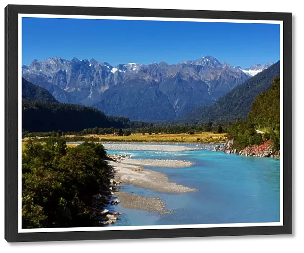 Turquoise-colored Whataroa River with snowcapped Southern Alps on horizon on autumn