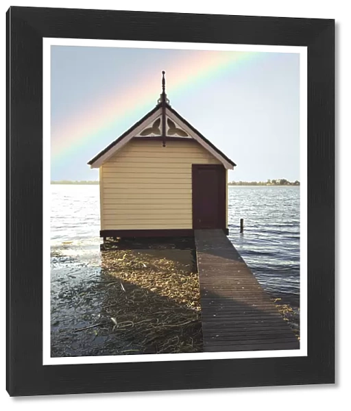 Boat shed with rainbow in sky