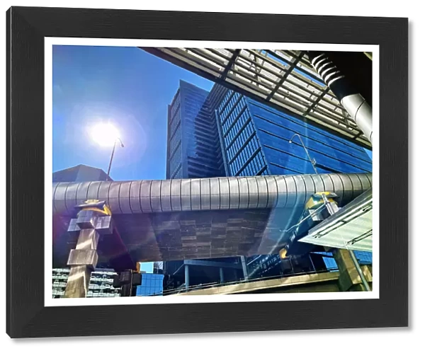 Futuristic global city, office buildings, highway overpass with sun and lens flare