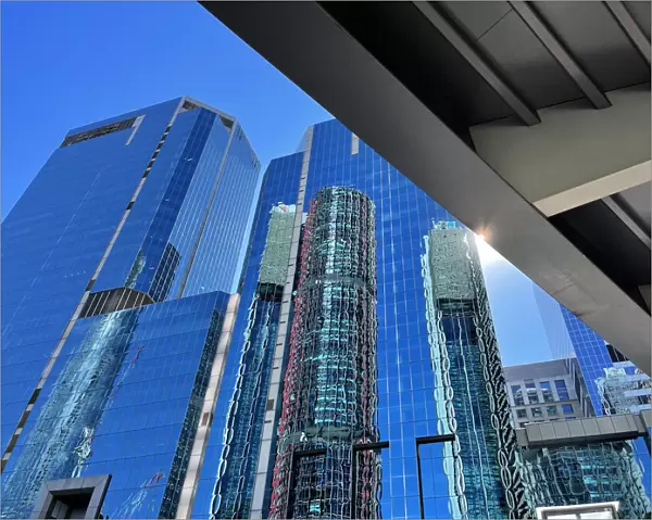 Glass skyscrapers, office buildings, elevated walkway bridge, lens flare, blue sky