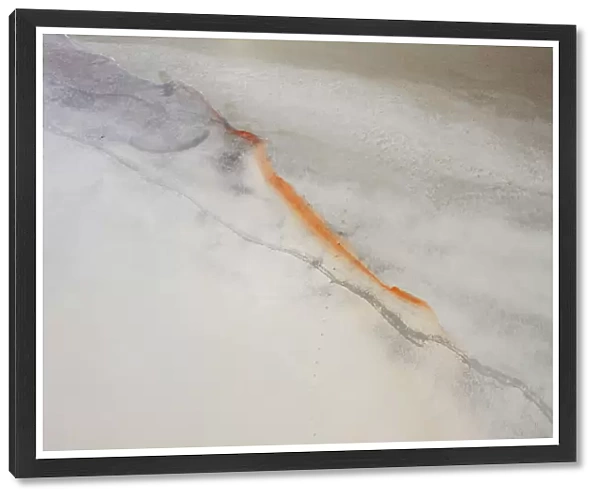 Aerial view point over white and grey colored salt lake with orange line of color