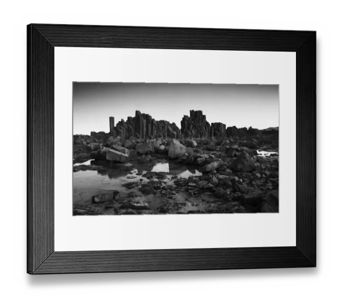 Framed Print : Monochrome, Dramatic coastal basalt columns rock formations at sunset at the disused