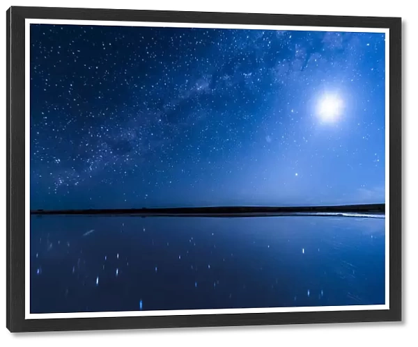 Vivid blue night sky, Milky Way galaxy and Full Moon shining in a starry sky, reflecting over Lake Tyrrell, Australian landscape