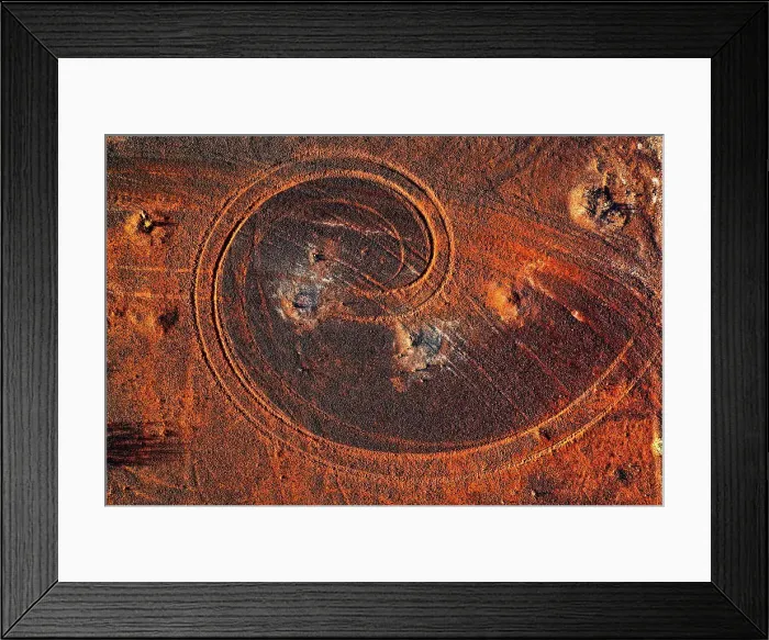 Framed Print : Abstract swirl pattern from car tyre tracks in red dirt, illuminated by dusk sunlight, remote rural Australia