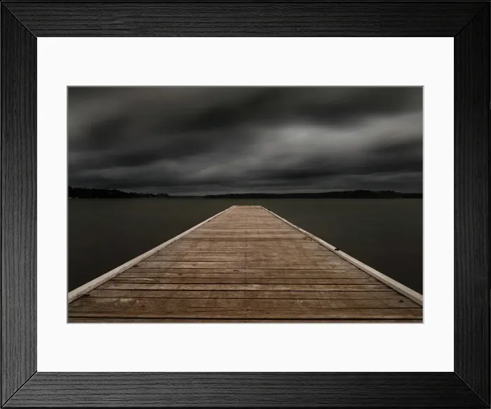 Framed Print : jetty out onto the lake with dark moody clouds
