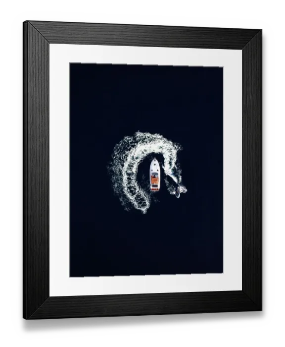 Framed Print : Aerial view of a jet ski swirling around a recreational boat