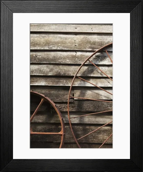 Framed Print : Old Wagon Wheels Against A Wooden Wall Framed Print : Old Wagon Wheels Against A Wooden Wall