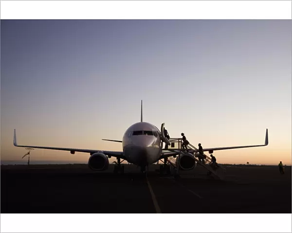People boarding an airplane at dusk, Port Hedland, Western Australia, Australia