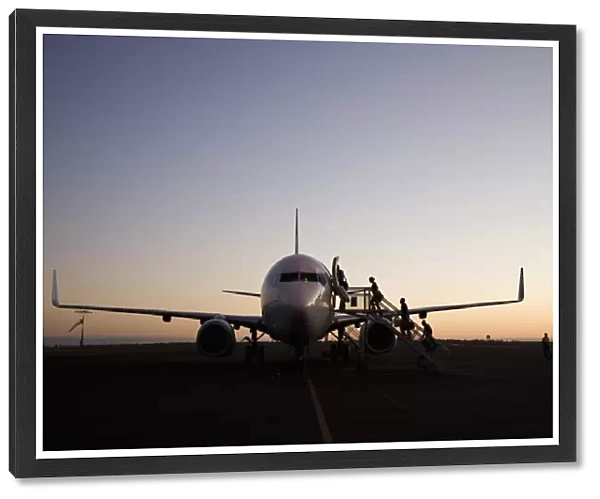 People boarding an airplane at dusk, Port Hedland, Western Australia, Australia