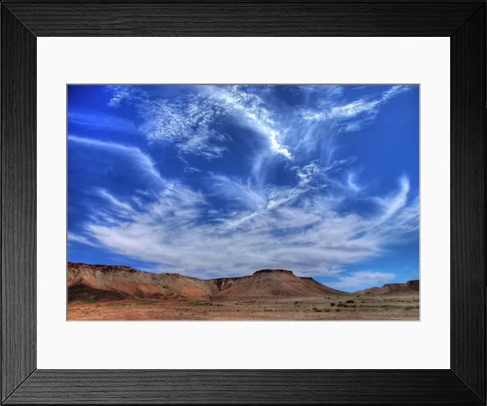 Framed Print : Wispy clouds over desert