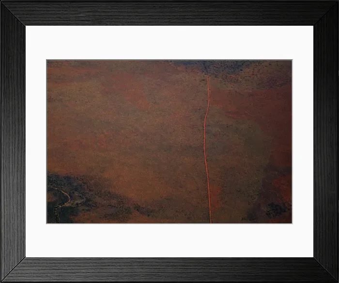 Framed Print : Aerial view of a dirt road positioned in a remote landscape