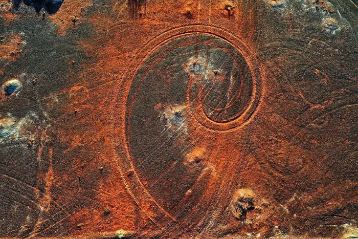 Framed Print : Abstract swirl pattern from car tyre tracks in red dirt, illuminated by dusk sunlight, remote rural Australia Framed Print : Abstract swirl pattern from car tyre tracks in red dirt, illuminated by dusk sunlight, remote rural Australia