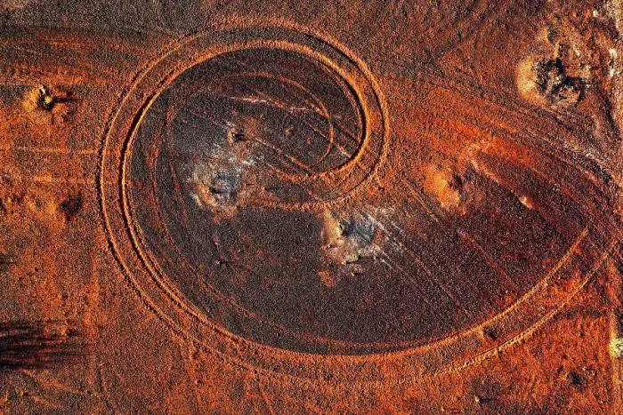 Framed Print : Abstract swirl pattern from car tyre tracks in red dirt, illuminated by dusk sunlight, remote rural Australia