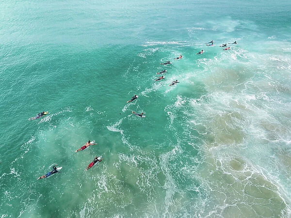 Aerial shot showing surfers paddling out to the waves on the Coral Sea, Gold Coast, Queensland, Australia