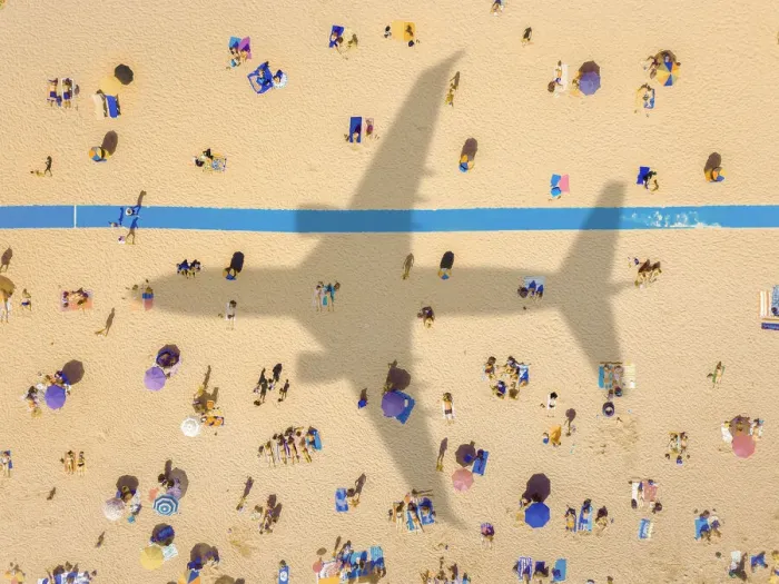 Framed Print : Aerial view of an airplane shadow over a crowded sandy beach
