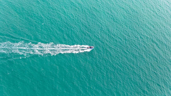 Aerial view of fast travelling boat on an island
