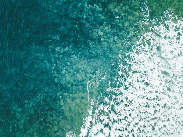 Aerial view of a female surfer on the ocean